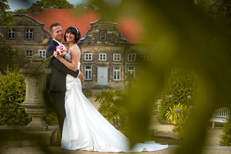 Hochzeit Harz – Brautpaar Hand in Hand vor dem Schloss